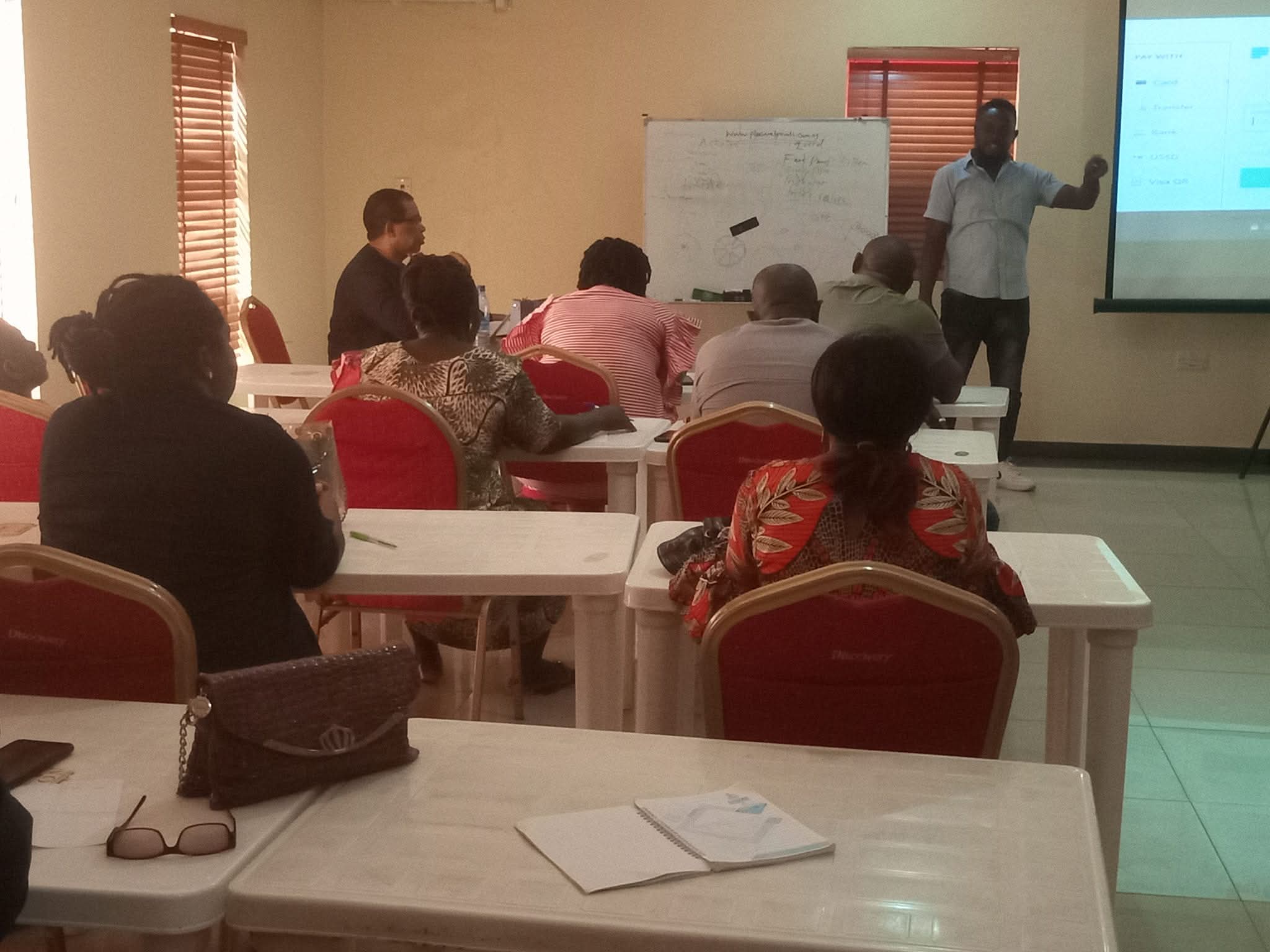 Bernard Okpe conducting an interactive training session with participants in a professional classroom setting